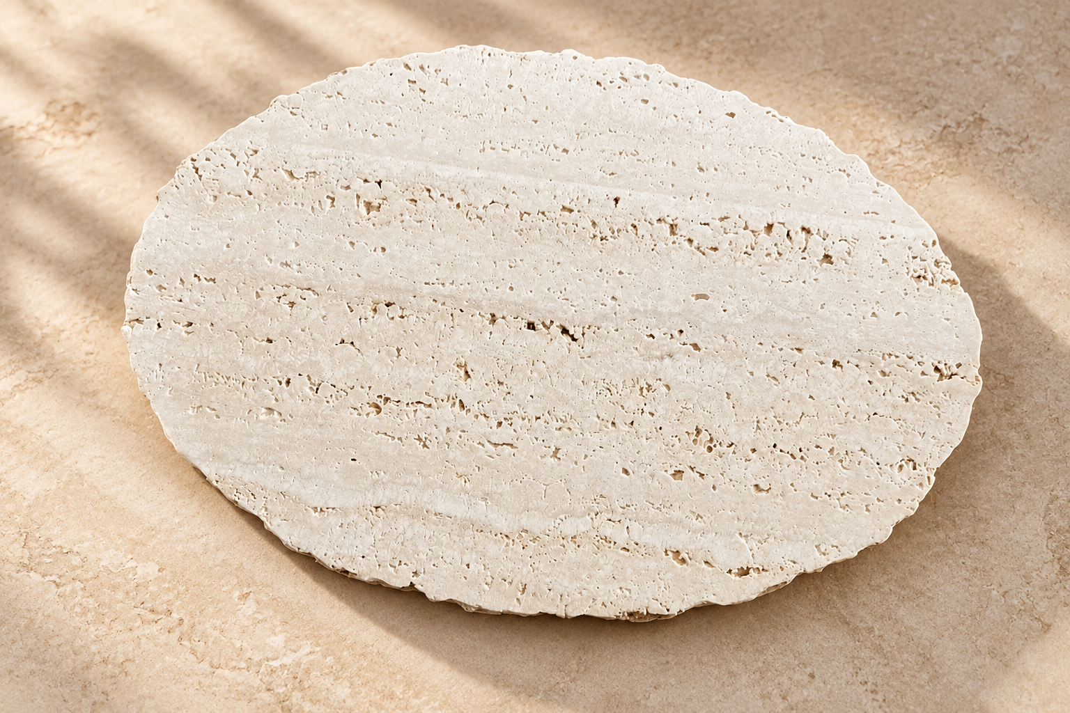 Base Mary em travertino natural, com formato orgânico alongado e borda irregular, sobre superfície bege